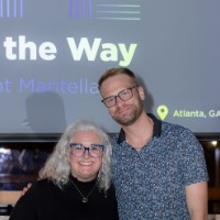 Director of Alumni Relations poses with a man in front of presentation